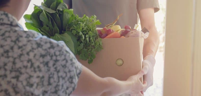 Une personne offrant un bac de légumes