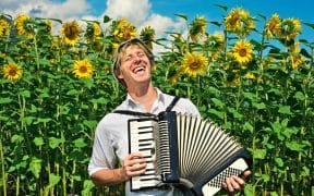 Agriculteur chantant avec un accordéon dans un champ