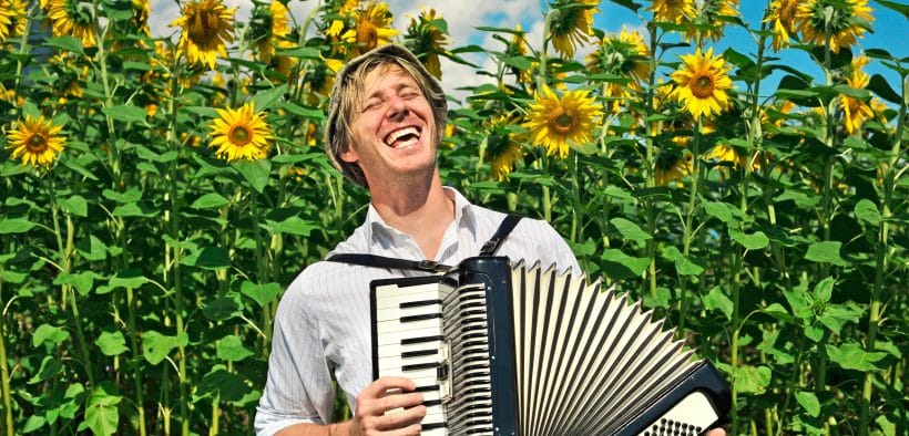 Agriculteur chantant avec un accordéon dans un champ