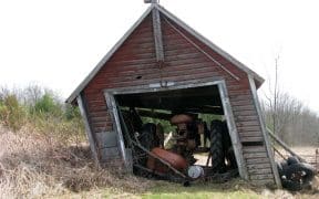 Un vieux tracteur dans une grange qui s'écroule