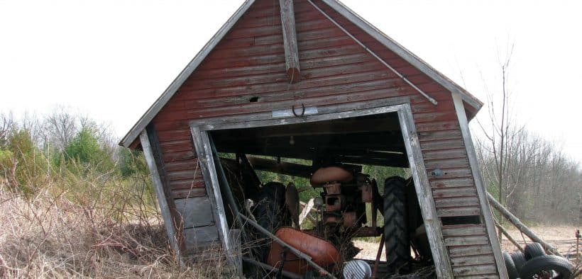 Un vieux tracteur dans une grange qui s'écroule