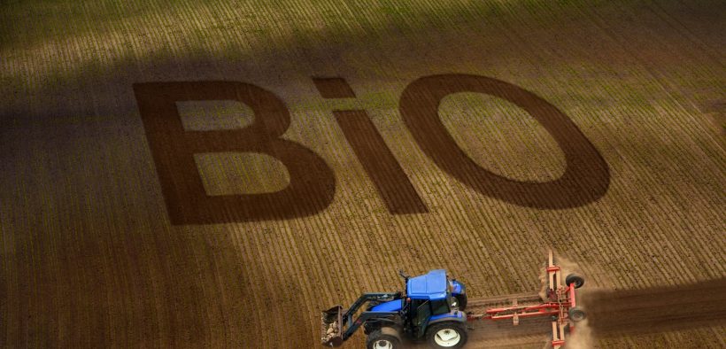 Tracteur dans un champ avec l'écriture "BIO"