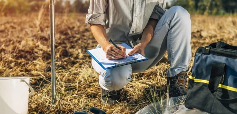 L'analyse des sols. Agronomes féminines prenant des notes en extérieur